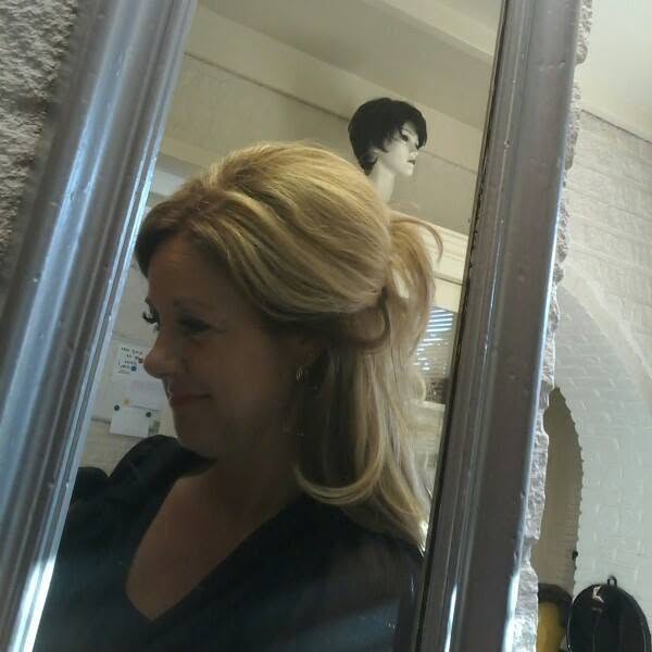 Dianne Roordink bij de spiegel in de haarwerkboetiek